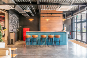 Espace cafétéria avec comptoir bleu et tabourets orange