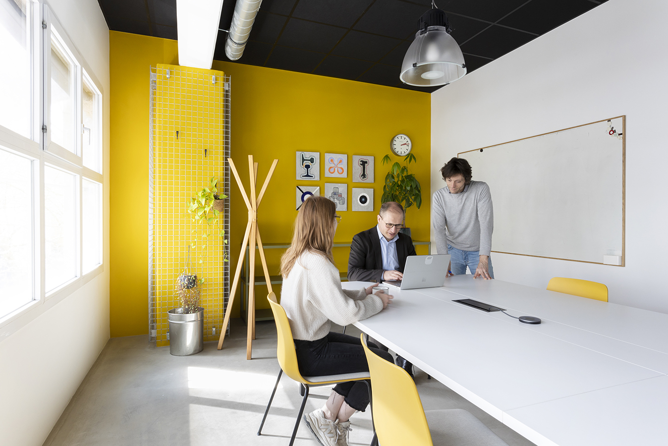 Réunion d'équipe dans une salle aux murs jaunes